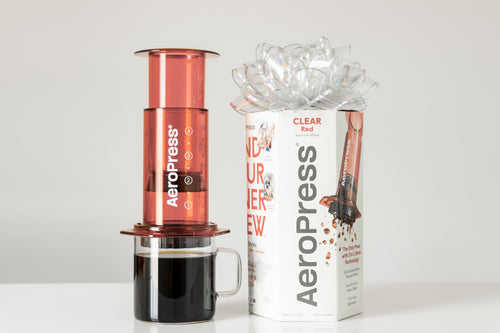 AeroPress Clear coffee maker being pressed into a glass